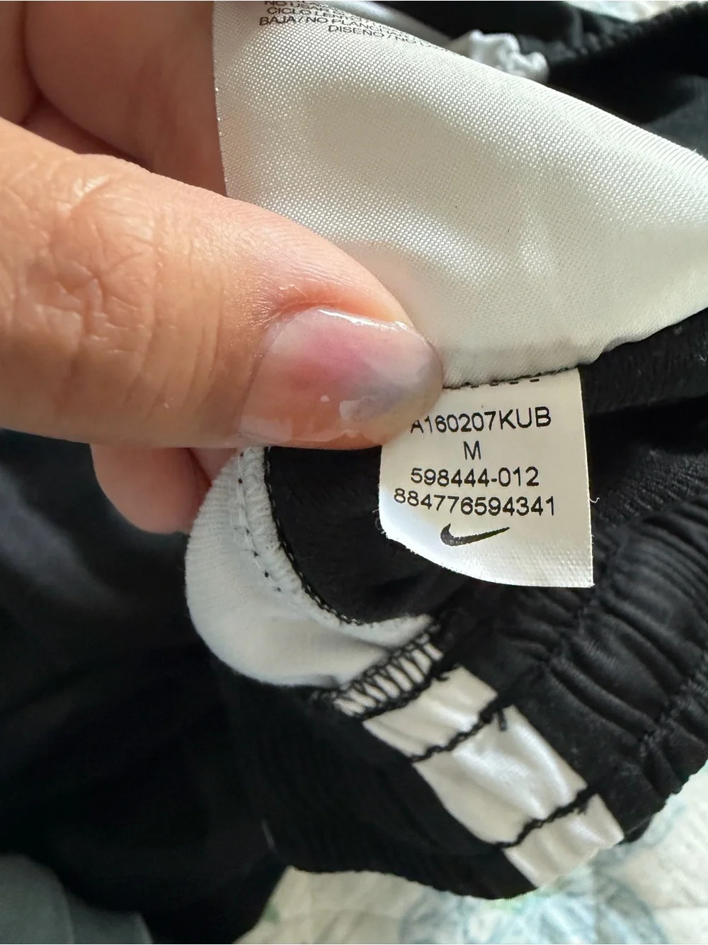 Nike black men’s track pants with white side stripes, size M